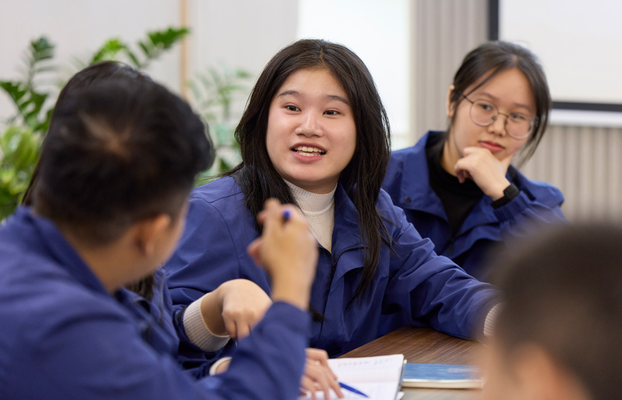 Employees in classroom setting collaborate or share learning